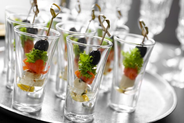 Fresh tasty canapes in glass cups closeup