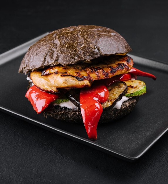 Fresh tasty chicken burger on a black tray