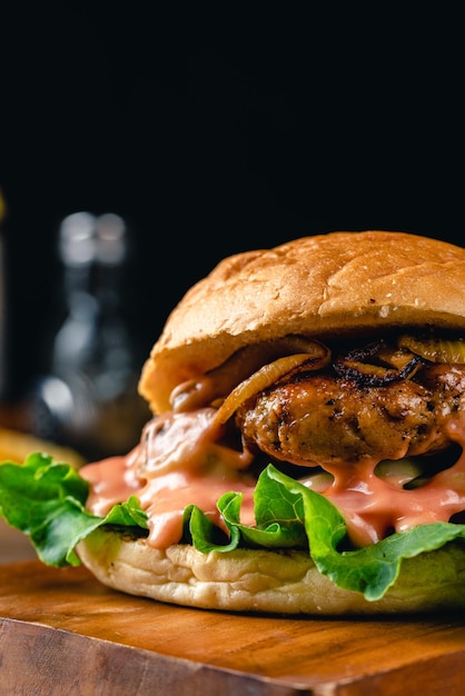 Fresh tasty chicken burger on wood table dark mood photography