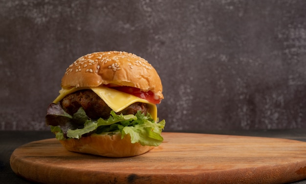 Fresh tasty homemade hamburger with fresh vegetables on a cutting board.