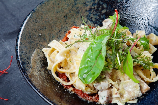 바질, 토마토와 버섯 어두운 그릇에 신선 하 고 맛있는 수 제 이탈리아 파스타. 이탈리아 요리. 음식 사진 배경 복사 공간입니다.