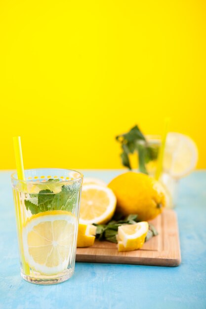 Fresh and tasty lemonade in two glasses next to cut lemons