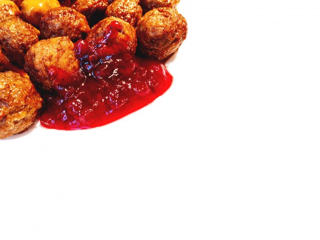 Fresh tasty meatballs with cranberry sauce on white background. Place for text.