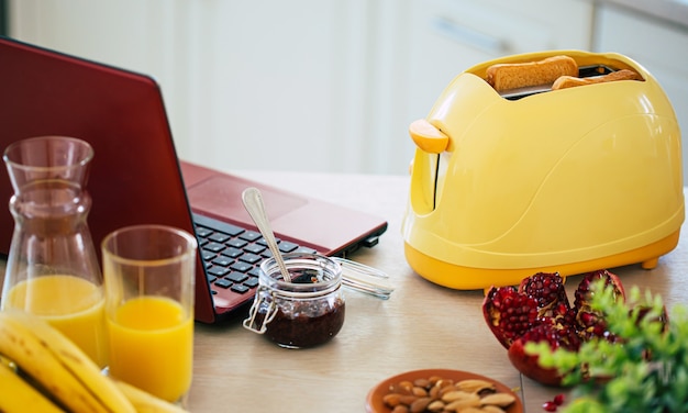 Fresh tasty slices of toasts from the yellow toaster on the beautiful kitchen table at home