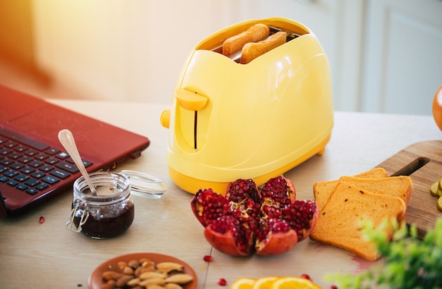 fresh tasty slices of toasts from the yellow toaster on the beautiful kitchen table at home