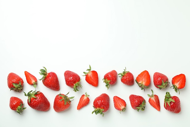 Fresh tasty strawberry with leaves on white surface