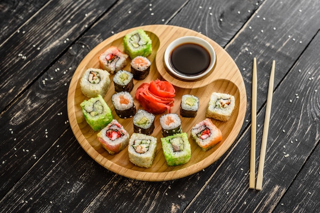 Fresh and tasty sushi on dark background. It can be used as a background