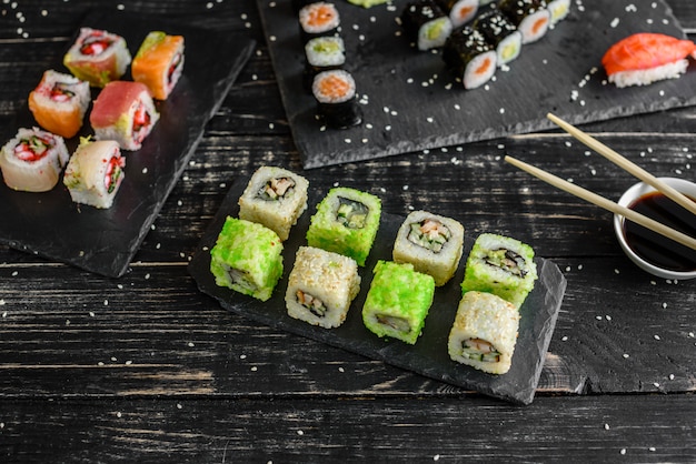 Fresh and tasty sushi on dark background. It can be used as a background