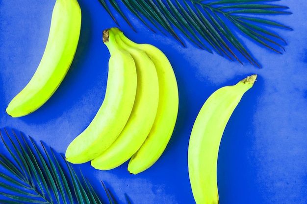 Свежие вкусные желтые бананы на синем фоне Концепция здорового питания Минимальная концепция