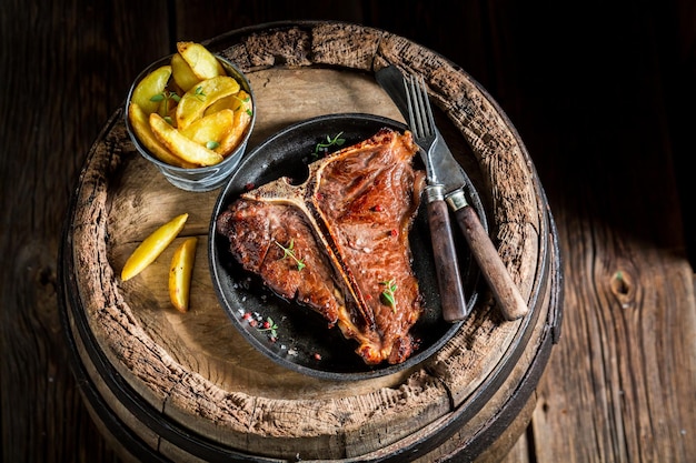 Foto bistecca fresca con l'osso e patatine con sale e pepe