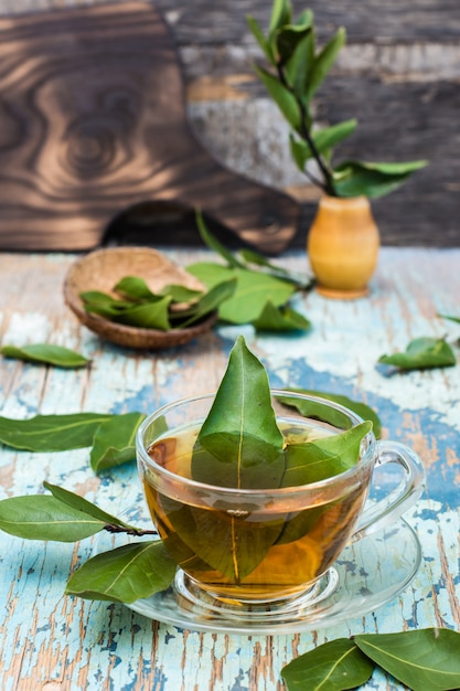 Fresh tea from bay leaf in a cup on a wooden rustic table