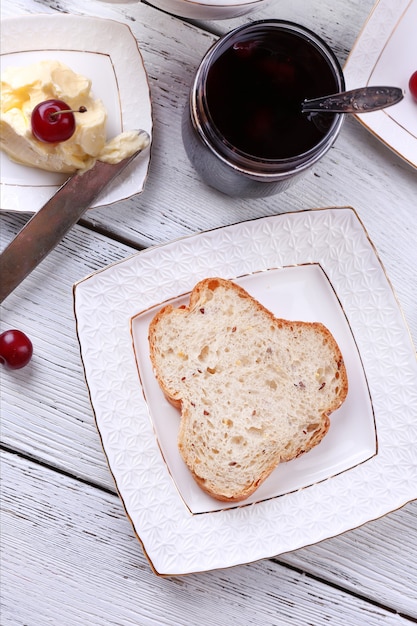 Fresh toast with homemade butter on plate on wooden table