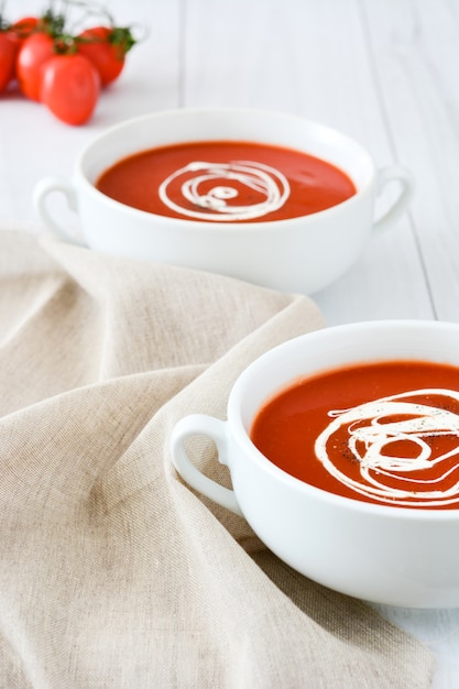 Photo fresh tomato soup in a white bowl on white wooden table