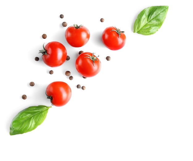 Fresh tomatoes and basil leaves on white background top view