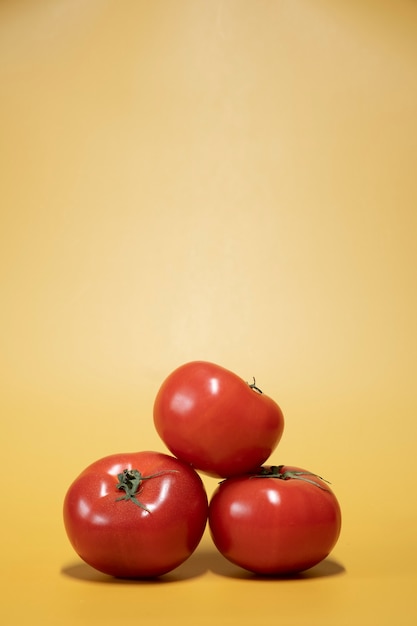 Foto pomodori freschi su uno sfondo giallo brillante in uno stile fotografico di cibo pubblicitario. cornice verticale