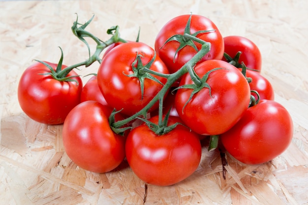 Pomodori freschi su un mazzo sopra la tavola di legno