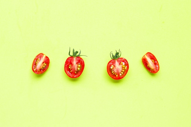 신선한 토마토, 절반 잘라 녹색 배경에 고립.