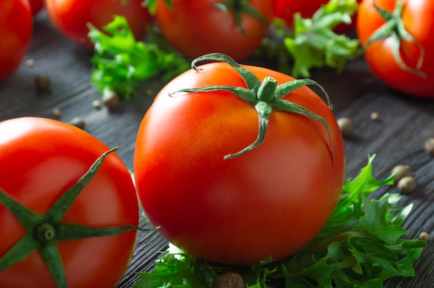 Fresh tomatoes, lettuce and spices on wooden table.