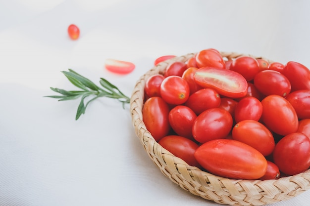 Fresh tomatoes and rosemary on a white background.