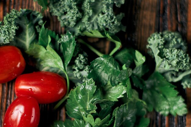 Fresh tomatoes and sprigs of parsley on a wooden table