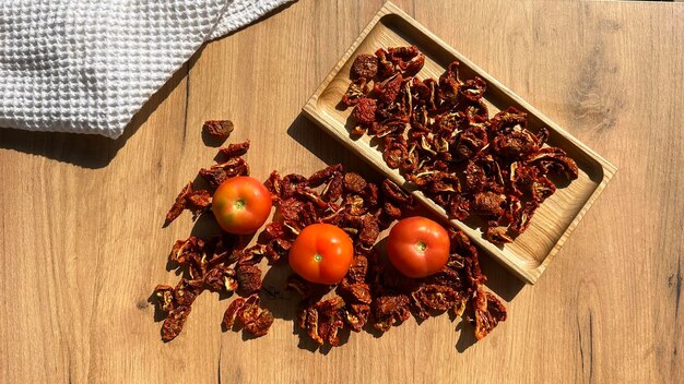 Fresh tomatoes and sun dried tomatoes together on wooden background