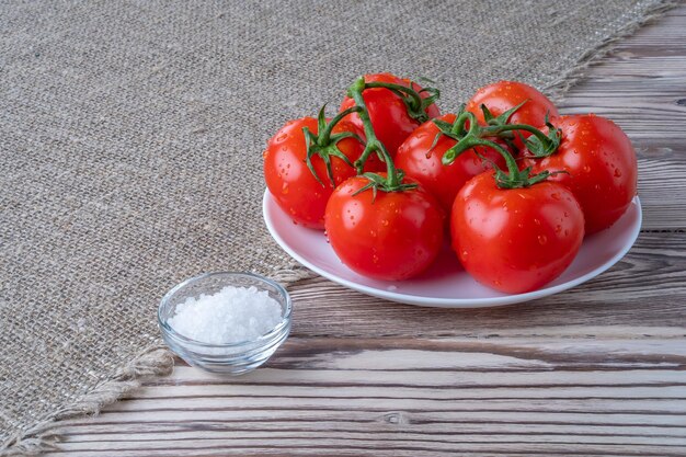 Fresh tomatoes tomato juice with salt cup with juice tomatoes on the background