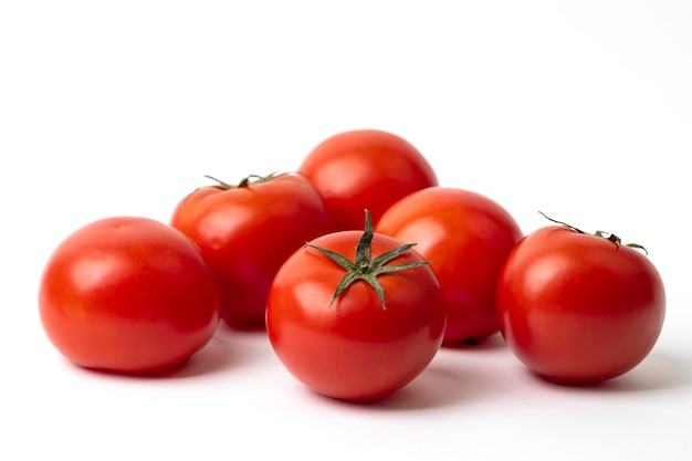 Fresh tomatoes on white surface