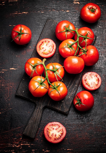 Fresh tomatoes on a wooden cutting board