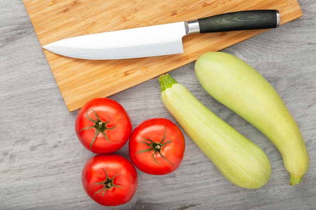 Fresh tomatoes and zucchini on wooden table