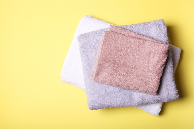 Fresh towels on a colored background with place for text top view