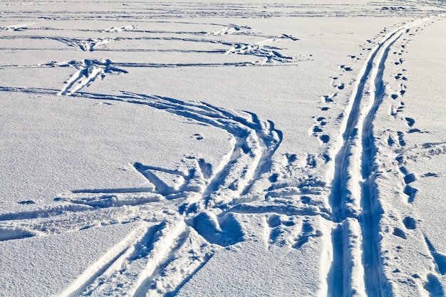 Fresh tracks in snowy field in winter day