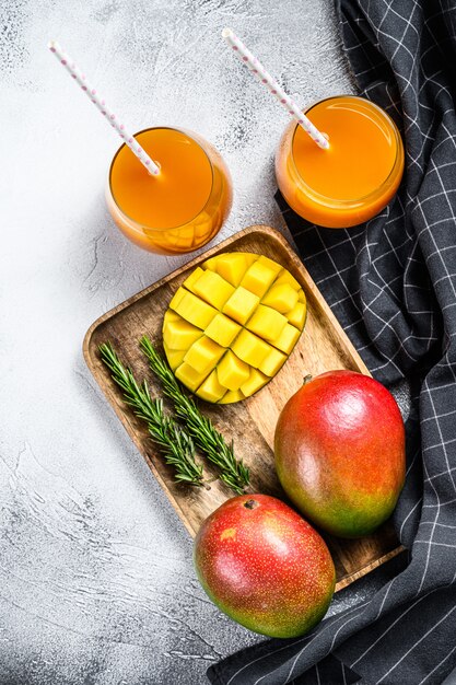 Fresh tropical fruit smoothie mango juice and fresh mango. Gray background. Top view