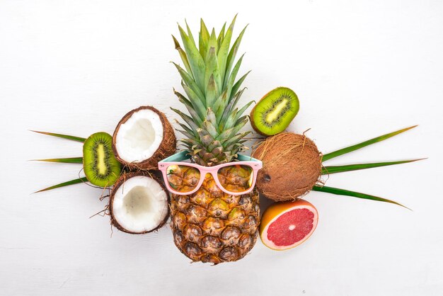 Fresh Tropical Fruits Coconut pineapple kiwi and grapefruit On a wooden background Top view Free space for text