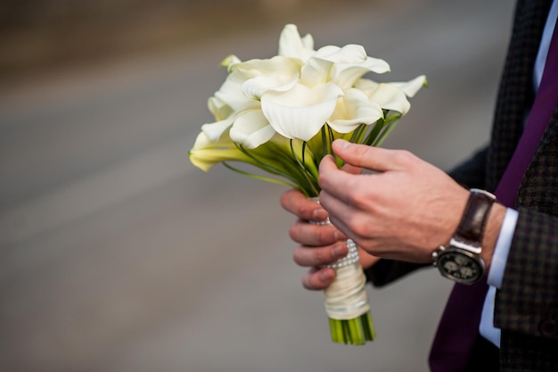 Fresh tulip bouquet in hands of the groom