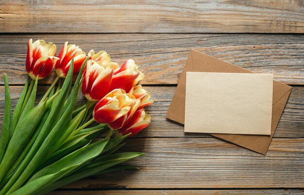 Fresh tulips on wooden background with space for text flat lay