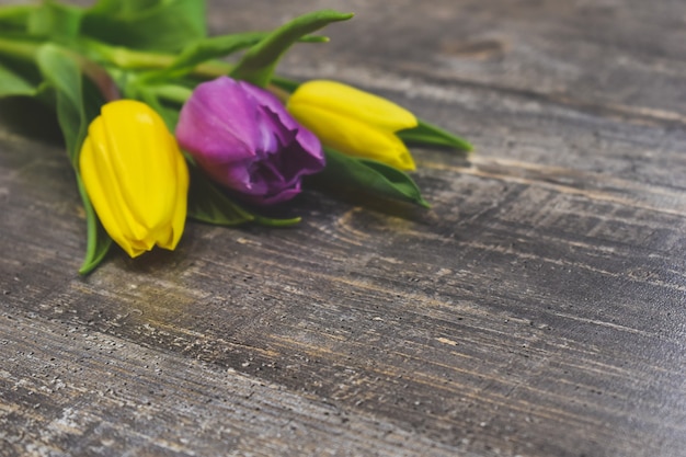 fresh tulips on wooden table