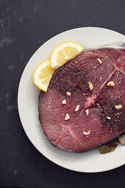 Photo fresh tuna with lemon on white plate