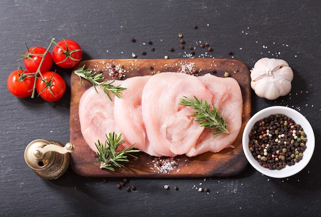 Fresh turkey meat on wooden board, top view