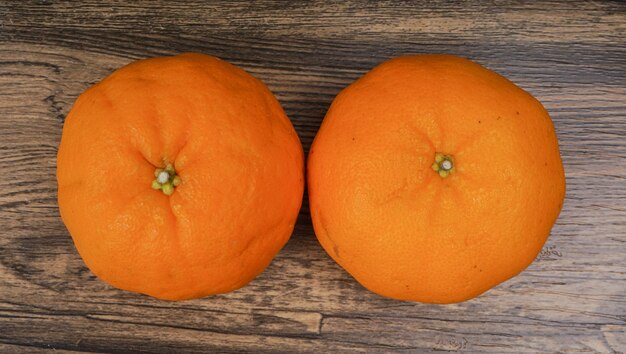 Fresh two tangerines over wooden table