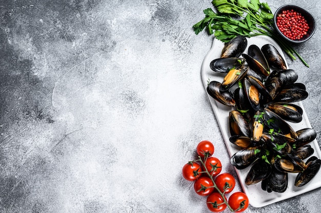 貝殻の新鮮な生ムール貝。パセリとトマトソースで調理の概念。テキスト用のスペース