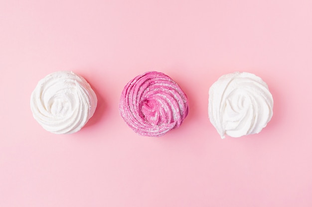 Foto caramelle gommosa e molle fresche della bacca e della vaniglia su un fondo di rosa pastello.