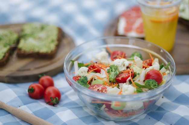 Fresh vegan salad outdoors on blue checkered napkin Vegan food concept outdoor