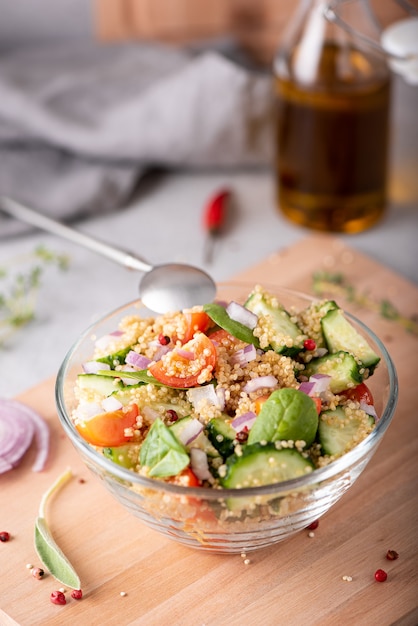 Fresh vegetable and quinoa salad in a glass bowl on the table, close-up