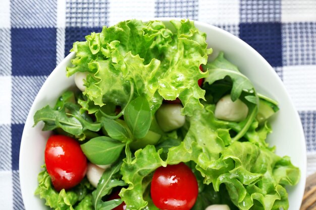 Салат из свежих овощей в миске на столе крупным планом