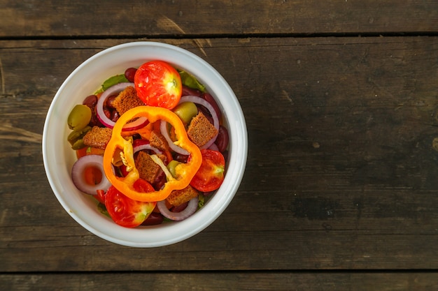 Photo fresh vegetable salad in a salad bowl on a wooden table. horizontal photo