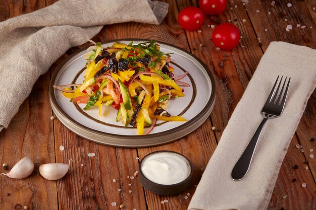 Fresh vegetable salad with oil, wooden background