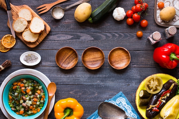 Photo fresh vegetable soup made at home, on wooden rustic table,  top view