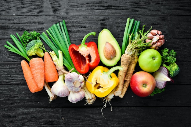 Fresh vegetables Avocado cucumber onion garlic tomatoes carrots horseradish Top view Free space for your text