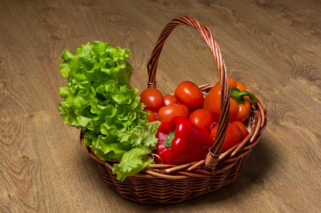 Fresh vegetables in basket on wooden table