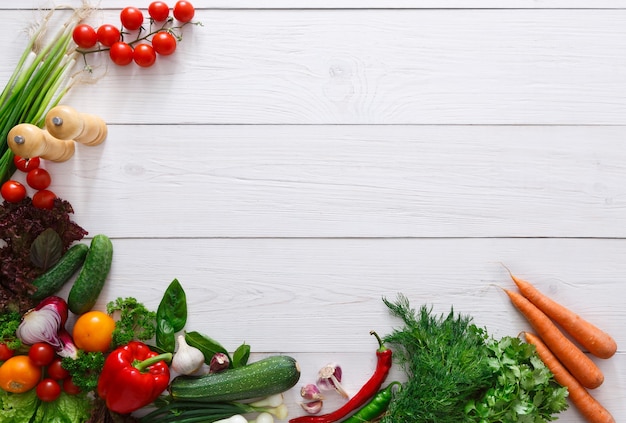 Fresh vegetables border on white wood with copy space